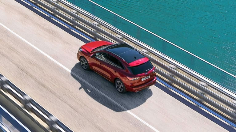 Red All-New Ford Kuga driving over bridge